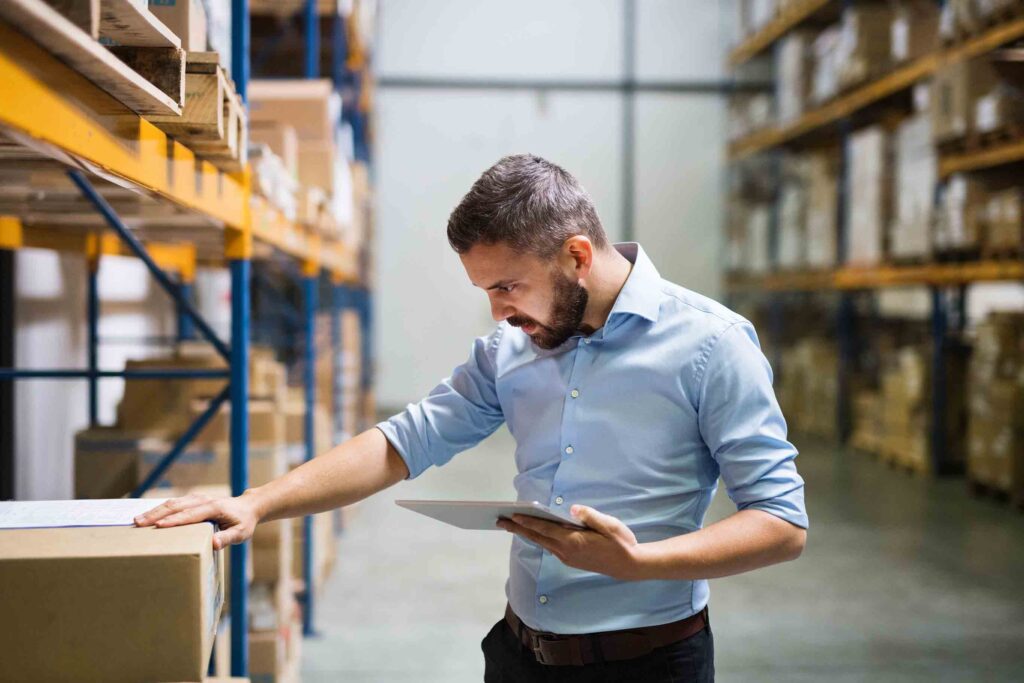 Business owner in a warehouse with a tablet.