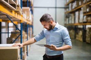 Business owner in a warehouse with a tablet.