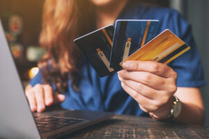 A woman holding credit cards, trying to consolidate her debts