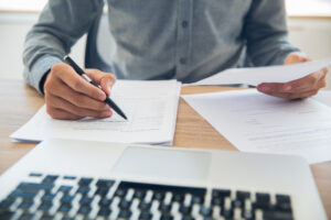Man going through his paperwork deciding whether he should refinance his loan or not