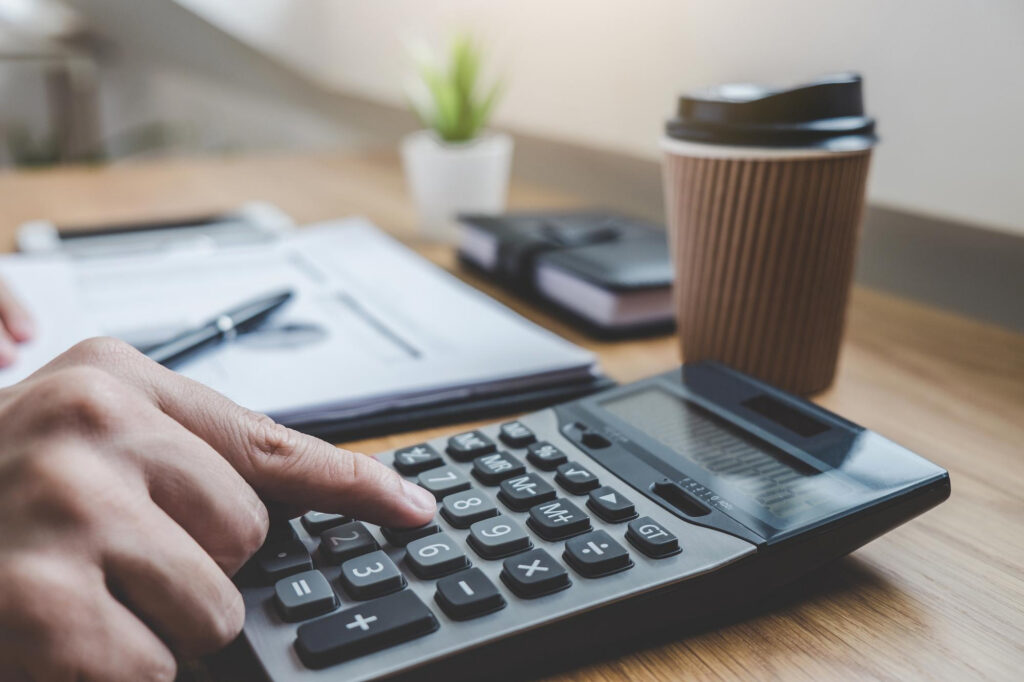 A person working out how to improve their borrowing capacity with a calculator