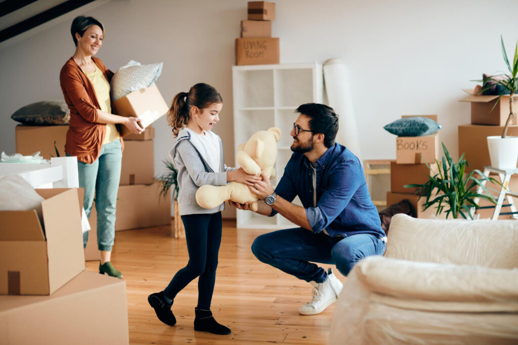 Happy family bringing their belongings into their new home, financed by DMC Finance