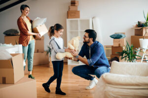 Happy family bringing their belongings into their new home, financed by DMC Finance